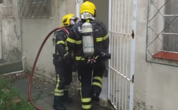 Fumaça em Correios mobiliza Bombeiros no centro de Meleiro Dois Bombeiros Militares com equipamentos de oxigênio inspecionando a porta dos fundos da agência dos Correios de Meleiro, após o acionamento de sistema de segurança que gerou fumaça no interior do prédio.