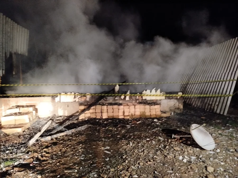Incêndio em Timbé do Sul Casa é destruída pelo fogo Escombros carbonizados e base de tijolos de uma casa de madeira, com fumaça subindo e área isolada com fita, após ser totalmente destruída por incêndio no bairro Vila Nova, em Timbé do Sul.