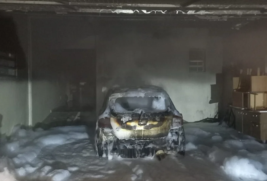 Carro Ford Ka completamente destruído e coberto por espuma (LGE) dentro da garagem, após incêndio que atingiu o Centro de Apoio a Idosos em Içara.