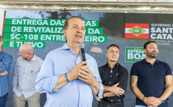 Jorginho Mello entrega revitalização da SC-108 em Meleiro Governador Jorginho Mello discursando em Meleiro no palco, em frente ao painel do Programa Estrada Boa, durante a entrega oficial da revitalização da rodovia SC-108, no trecho que liga Meleiro a Turvo (investimento de R$ 20 milhões).