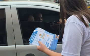 Morro da Fumaça inicia campanha Novembro Azul com blitz Profissional de saúde entregando folhetos informativos para motoristas e passageiros de carro em uma blitz, marcando o início da campanha Novembro Azul em Morro da Fumaça.