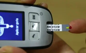 Novembro Azul: CBO alerta para risco de cegueira por diabetes Uso de um glicosímetro com uma fita-teste e gota de sangue, representando a importância do controle da diabetes para prevenir a retinopatia e o risco de cegueira, em alerta do CBO (Novembro Azul).