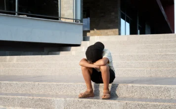 O que muda com a nova lei do abandono afetivo? Criança sentada sozinha e cabisbaixa em uma escadaria, representando o impacto do abandono afetivo que agora é reconhecido como violação legal pelo Estatuto da Criança e do Adolescente (ECA).