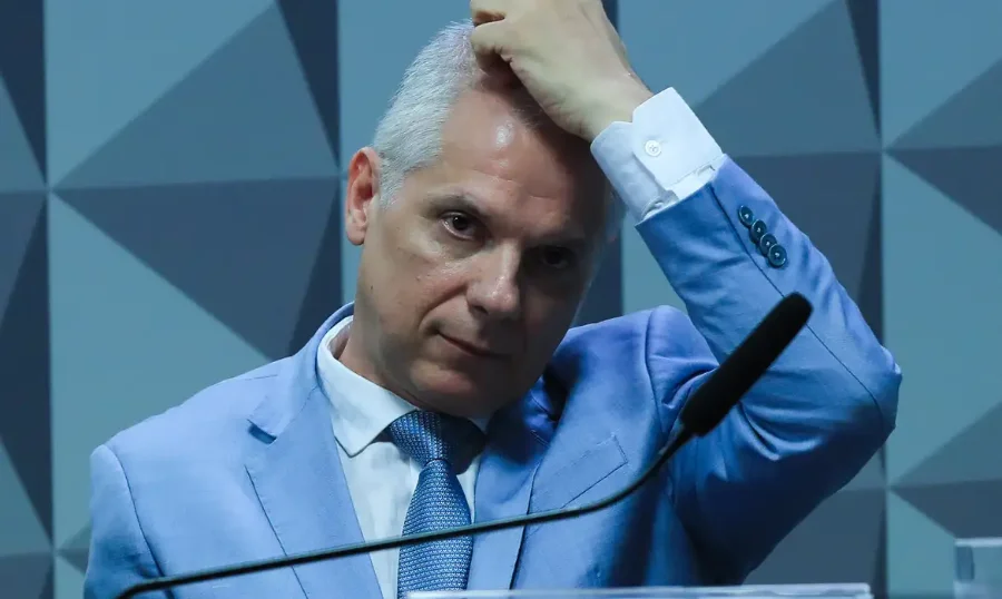 Ex-presidente do INSS, Alessandro Stefanutto, em close-up, gesticulando com a mão na cabeça, representando a tensão após ser preso pela Polícia Federal (PF) na Operação Sem Desconto, que investiga fraudes contra aposentados.