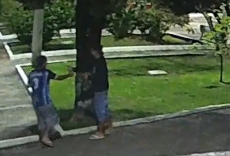 Polícia indicia dupla por vandalismo em enfeites de Timbé do Sul Imagem de câmera de segurança mostrando dois homens junto a uma árvore na praça, representando a dupla indiciada pela Polícia Civil por vandalismo em enfeites de Natal em Timbé do Sul.