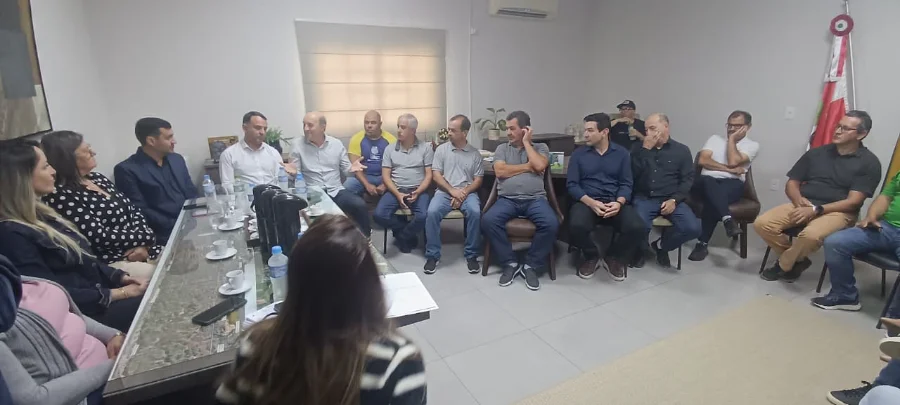 Deputado Zé Milton Scheffer e vice-prefeito Jonatã Coelho reunidos em mesa com secretários e vereadores para discutir projeto de acesso rodoviário.