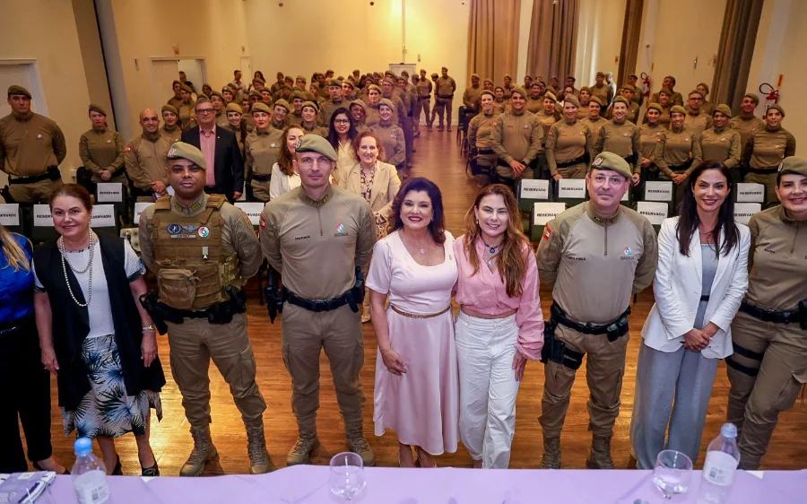 Vice-Governadora Marilisa Boehm e oficiais da Polícia Militar de Santa Catarina (PMSC) posando em frente a uma grande plateia de policiais, durante o 1º Seminário Estadual da Rede Catarina de Proteção à Mulher.