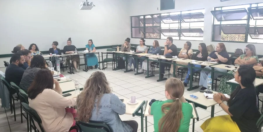 Profissionais de saúde mental e gestores de diversos municípios de Santa Catarina reunidos em sala de aula (em círculo), durante o encontro do Projeto Nós na Rede para qualificação e fortalecimento da Rede de Atenção Psicossocial (RAPS) do SUS.