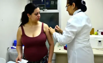 SUS oferecerá vacina contra VSR a gestantes em dezembro Profissional de saúde aplicando uma vacina no braço de uma mulher grávida, em uma Unidade Básica de Saúde.
