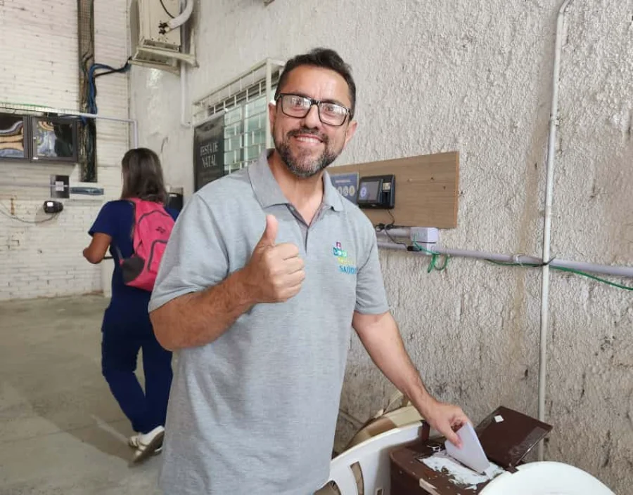 Sindisaúde reelege Cleber Cândido com 96% dos votos Presidente do Sindisaúde, Cleber Cândido, sorrindo e fazendo um 'joinha' enquanto deposita seu voto na urna, após ser reeleito com 96% dos votos para liderar o sindicato de Criciúma e Região.