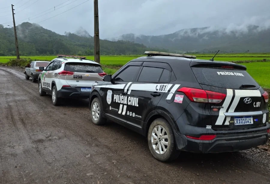 Timbé do Sul homem é preso por descumprir medida protetiva Viaturas das Polícias Civil e Militar de Santa Catarina (SC) estacionadas em uma estrada de chão na comunidade de Urussanguinha, ilustrando a ação integrada que prendeu um homem por descumprimento de medida protetiva em Timbé do Sul.