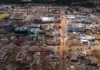 Governo Federal cria GT para crise de tornado no Paraná Vista aérea do centro de Rio Bonito do Iguaçu (PR) após ser atingida por um tornado, mostrando casas e edifícios comerciais totalmente destruídos e escombros espalhados pelas ruas, em meio ao apelo urgente por doações para a reconstrução.
