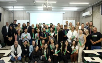 Unesc encerra imersão de chilenos no SUS brasileiro Grande grupo de 26 profissionais de saúde chilenos, ao lado de professores da UNESC, posando com certificados após a imersão de dez dias no funcionamento do SUS brasileiro.