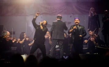 Unesc presenteia Centenário de Criciúma com show da Camerata Músicos da Camerata Florianópolis se apresentam no palco com violino e microfone, sob luzes coloridas durante um show.