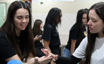 Unesc realiza Feira Científica sobre rios saudáveis Duas estudantes interagindo em um estande na Feira Científica "Rios Saudáveis" da UNESC, que reuniu 250 alunos para aprendizado interativo sobre a preservação de recursos hídricos.
