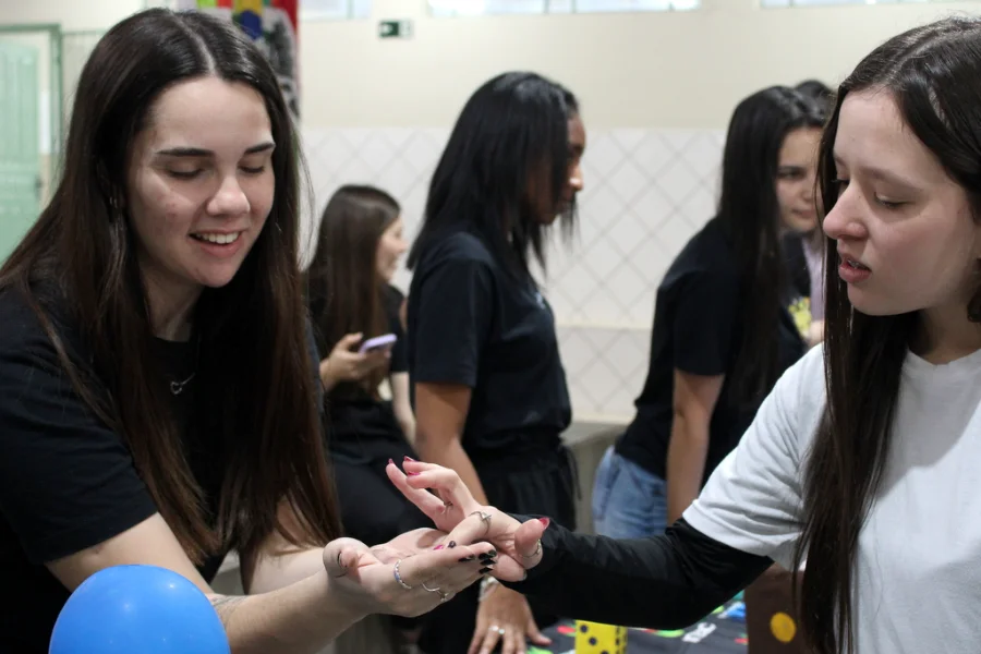 Duas estudantes interagindo em um estande na Feira Científica 