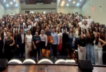 Unesc sedia Jornada de Biomedicina com recorde de inscrições Auditório lotado com mais de 300 acadêmicos do curso de Biomedicina (UNESC), e a reitora Gisele Coelho Lopes e equipe organizadora no palco, celebrando o recorde de inscrições da 11ª Jornada Acadêmica em Criciúma.