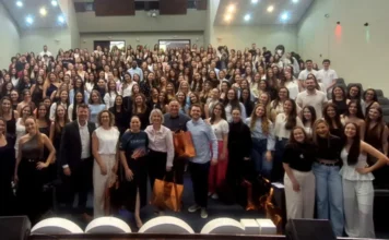 Unesc sedia Jornada de Biomedicina com recorde de inscrições Auditório lotado com mais de 300 acadêmicos do curso de Biomedicina (UNESC), e a reitora Gisele Coelho Lopes e equipe organizadora no palco, celebrando o recorde de inscrições da 11ª Jornada Acadêmica em Criciúma.