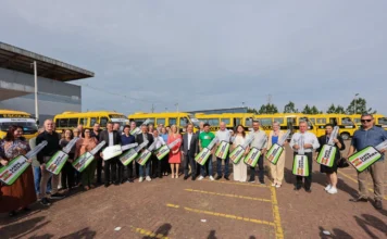 SC entrega 100 novos ônibus para estudantes da rede pública várias pessoas em frente de ônibus amarelos