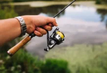 FGTAS detalha mudanças no Seguro-Desemprego do Pescador uma mão segurando uma vara de pesca