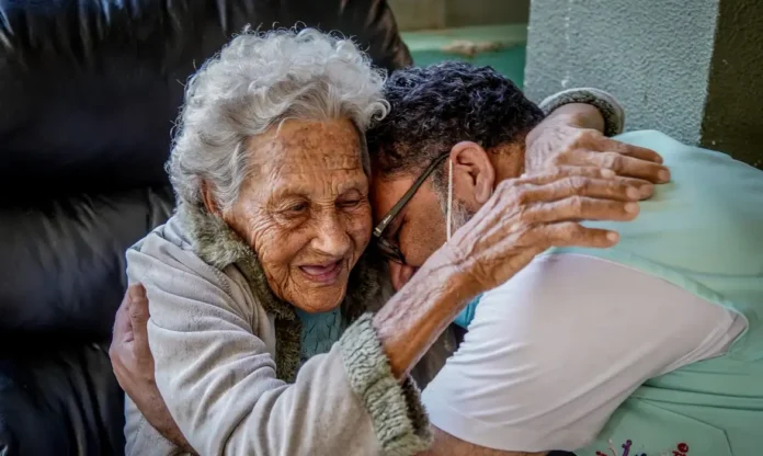 raf06068 uma idosa e um jovem abraçados