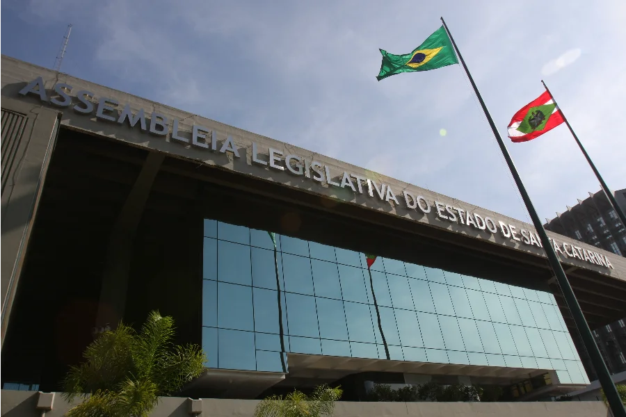 Fachada externa do Palácio Barriga Verde, sede da Alesc, com destaque para o letreiro metálico e as bandeiras do Brasil e de Santa Catarina hasteadas. O prédio terá atividades suspensas até 4 de janeiro devido ao recesso.