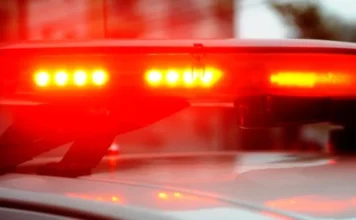 Araranguá: Homem é detido por ameaçar companheira de morte Close-up das luzes vermelhas de emergência (giroflex) ligadas sobre o teto branco de uma viatura policial.