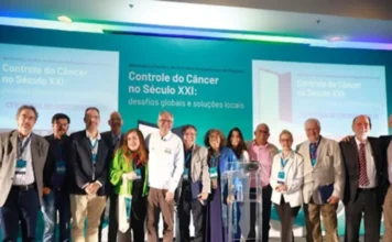 Brasil terá maior rede pública de tratamento de câncer do mundo Grupo de especialistas e autoridades, incluindo o Ministro Alexandre Padilha, posam em palco com um banner de fundo sobre "Controle do Câncer no Século XXI".