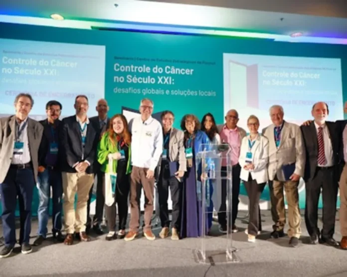 Brasil terá maior rede pública de tratamento de câncer do mundo Grupo de especialistas e autoridades, incluindo o Ministro Alexandre Padilha, posam em palco com um banner de fundo sobre "Controle do Câncer no Século XXI".