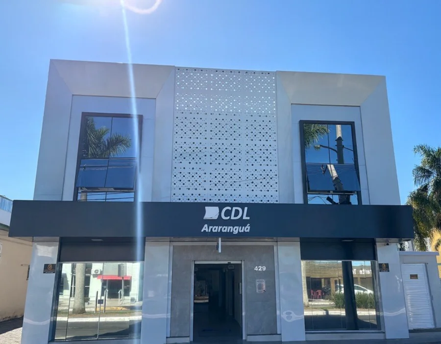 CDL Araranguá é contra aumento de pedágio na BR-101 Sul Fachada moderna da sede da CDL (Câmara de Dirigentes Lojistas) de Araranguá, em tons de cinza e branco, sob céu azul.