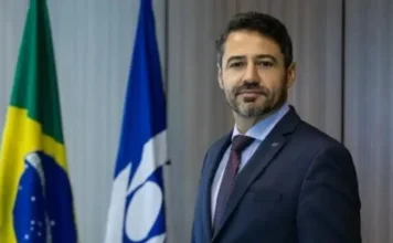 CGU encerra processo e demite ex-secretário da Receita Federal O ex-secretário da Receita Federal, Julio Cesar Vieira Gomes, posa de terno ao lado de bandeiras do Brasil.