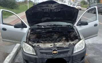 Carro pega fogo na Beira-Mar de Balneário Gaivota Chevrolet Celta com motor queimado após incêndio em Balneário Gaivota. Bombeiros utilizaram 500 litros de água para extinguir as chamas no centro da cidade durante a manhã de Réveillon.