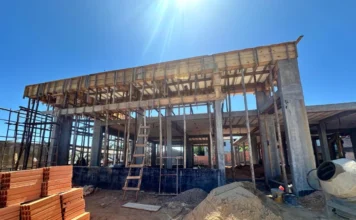 Cocal do Sul constrói nova ESF Centro para 3,6 mil pacientes Estrutura de concreto em construção da nova unidade de saúde ESF Centro em Cocal do Sul, com escoramentos de madeira e tijolos em primeiro plano.