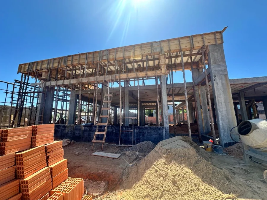 Cocal do Sul constrói nova ESF Centro para 3,6 mil pacientes Estrutura de concreto em construção da nova unidade de saúde ESF Centro em Cocal do Sul, com escoramentos de madeira e tijolos em primeiro plano.