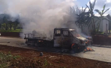 Criciúma: Caminhão de pequeno porte é destruído por incêndio Caminhão de pequeno porte em chamas na rua, com bombeiros ao redor controlando o fogo em Criciúma.