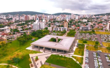 Criciúma: Cidade está entre as 50 melhores para se viver no Brasil Vista panorâmica da área central de Criciúma, mostrando prédios altos e edifícios em uma área urbana em meio a morros e vegetação.