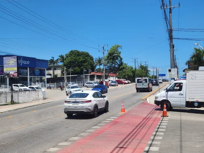 Criciúma libera trincheira e altera trânsito em Rio Maina Carros trafegando em uma avenida (Luiz Lazzarin) em Criciúma, com a trincheira recém-liberada à frente, sob forte sol e céu azul.