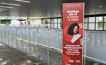 Criciúma realiza mais de mil testes rápidos de ISTs Totem vermelho no Paço Municipal de Criciúma com o texto "Cuidar de si é amar a vida" e a imagem de uma mulher sorrindo; promove a campanha Dezembro Vermelho.
