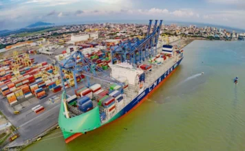 Exportações de SC caem 11% em novembro, diz FIESC Vista aérea do Porto de Itajaí (ou outro porto catarinense) com um grande navio porta-contêineres sendo carregado/descarregado por guindastes, ilustrando as exportações.