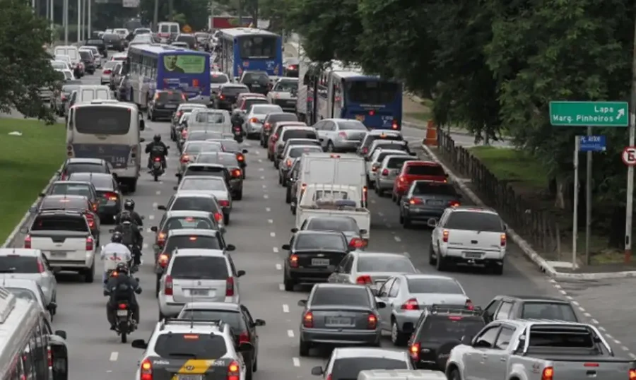 Congestionamento de carros e ônibus em uma avenida urbana, representando o tráfego e os veículos visados pela isenção de IPVA.