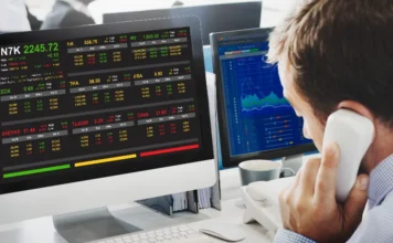 Mercado: Bolsa sobe por expectativa de juros menores em janeiro Operador do mercado financeiro em frente a monitores exibindo cotações de bolsa de valores, refletindo a alta do Ibovespa e a expectativa de corte de juros.