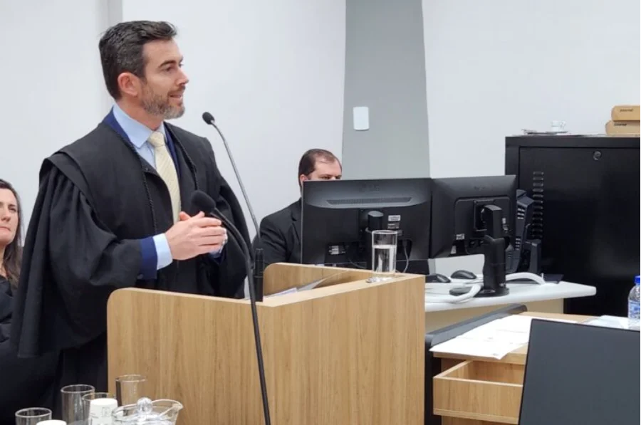 O procurador-geral Marcelo Mendes, vestindo beca, discursa em um púlpito de madeira durante balanço de 2025.