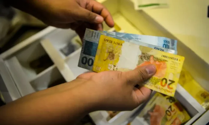 PIS Pasep 2025 Prazo para saque termina nesta segunda Mãos contando notas de Real. Prazo final para saque do abono salarial PIS/Pasep 2025 termina hoje; saiba como consultar o benefício via Caixa ou Banco do Brasil.