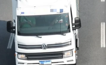 PRF usa drones com zoom de 56x para fiscalizar o Natal em SC Imagem capturada por drone da PRF mostrando a cabine de um caminhão branco da Volkswagen em uma rodovia, evidenciando a nitidez do zoom para fiscalização.