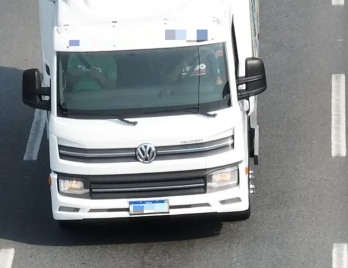 PRF usa drones com zoom de 56x para fiscalizar o Natal em SC Imagem capturada por drone da PRF mostrando a cabine de um caminhão branco da Volkswagen em uma rodovia, evidenciando a nitidez do zoom para fiscalização.