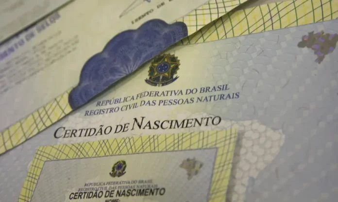 Queda de 5,8% Março é o mês com maior número de nascimentos Imagem de close-up de várias Certidões de Nascimento empilhadas. A parte central visível mostra o título "Certidão de Nascimento" e a inscrição "REPÚBLICA FEDERATIVA DO BRASIL REGISTRO CIVIL DAS PESSOAS NATURAIS", com o brasão da República. A imagem ilustra os documentos usados para compilar as estatísticas de nascimentos no país.