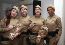 Rede Catarina: Curso foca em estudos de gênero e saúde mental Quatro policiais militares femininas formandas da Rede Catarina, uniformizadas, seguram buquês de flores e sorriem na formatura em Florianópolis.