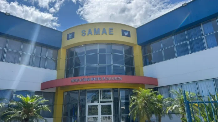 SAMAE de Araranguá abre seletivo com salários de até R$ 8,8 mil Fachada da sede do SAMAE (Serviço Autônomo Municipal de Água e Esgoto) de Araranguá, em prédio amarelo e azul, sob luz do sol.