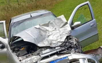 São João do Sul: Acidente na SC-290 deixa três feridos Carro de passeio prateado com a parte frontal completamente destruída e o capô retorcido após colisão em São João do Sul.