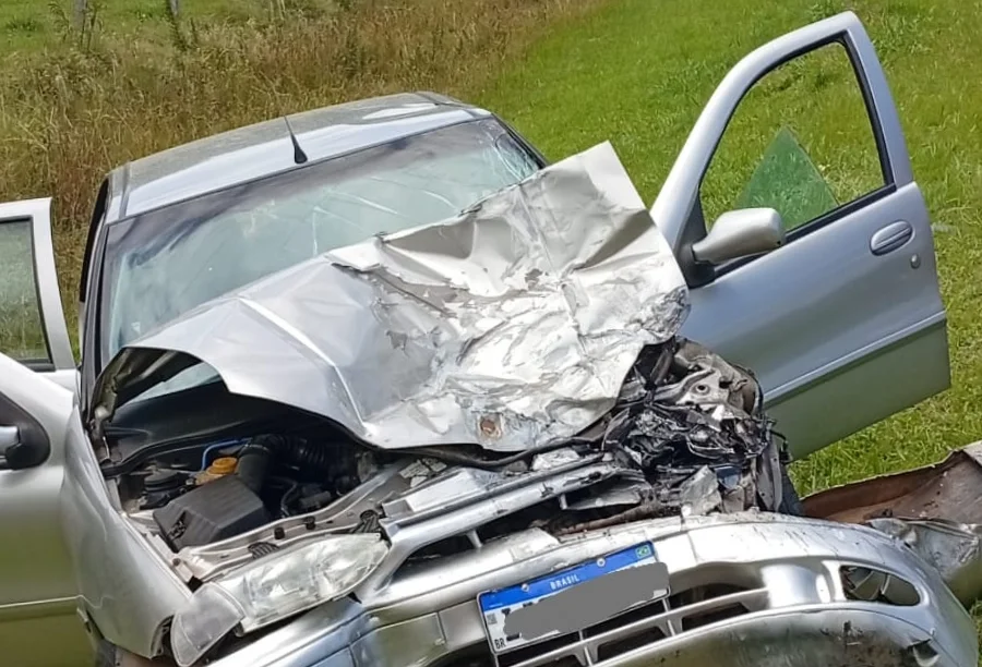 Carro de passeio prateado com a parte frontal completamente destruída e o capô retorcido após colisão em São João do Sul.